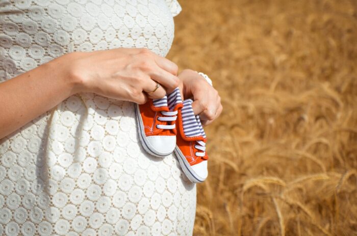 赤ちゃんの靴を持つ妊婦